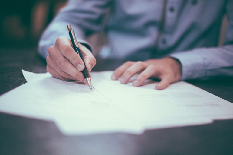 Amministratore d'azienda che firma il contratto di cessione dei requisiti SOA