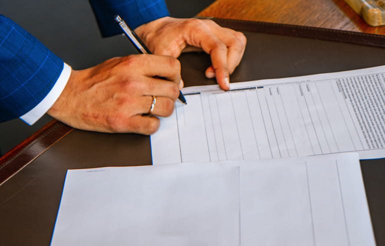 Imprenditore che firma contratto per la cessione di un'azienda edile